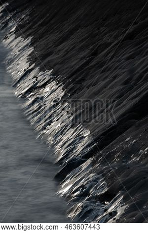 Abstract Landscape Image Of Rocks On Welcome Mouth Beach At Sunset With Tide Marks On Rocks Reflecti