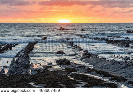 Stunning Sunset Landscape Image Of Welcome Mouth Beach In Devon England With Beautiful Rock Formatio