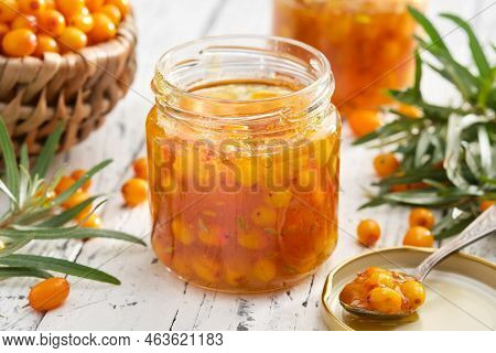 Jar Of Healthy Sea Buckthorn Jam. Basket Of Ripe Sea Buckthorn Berries On Background. A Spoonful Of 
