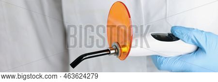 The Doctor Is Holding Dental Curing Light, Close-up. Instruments For Prosthetics Fillings, Solidify 