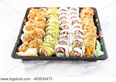 Pre-packaged Variety Of Sushi And Sushi Rolls In A Plastic Tray.