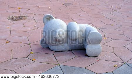 Concrete Decor Of A Sleeping Bear On The Pavement.