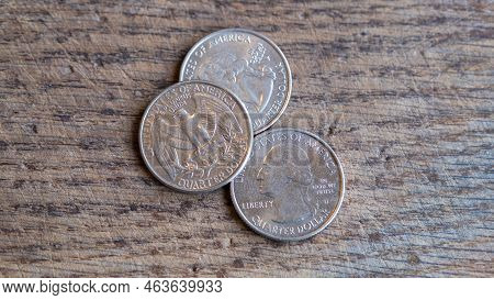 Close Up Of Quarter Dollar Coins. Financial Concept On Wooden Background.