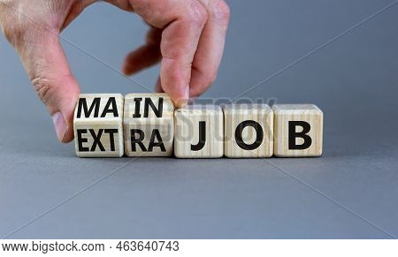 Extra Or Main Job Symbol. Businessman Turns Wooden Cubes And Changes Concept Words Extra Job To Main