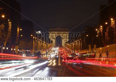 The Triumphal Arch And Champs-elysees Avenue In Rainy Evening, Paris, France.