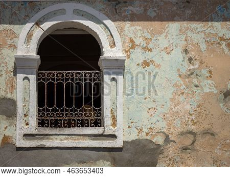 Old Wall With A Window And A Grille. Construction Concept Without Maintenance.