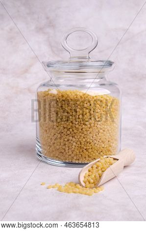 Traditional Dry Pearl Couscous In A Glass Jar On A Light Background. Selective Focus.
