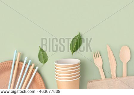 Eco - Friendly Tableware On Green Background. Top View. Plastic Free Set Of Brown Paper Utensil. Str
