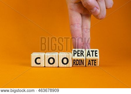 Coordinate And Cooperate Symbol. Businessman Turns Wooden Cubes And Changes The Word 'cooperate' To 