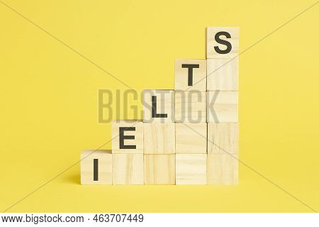 The Word Ielts Is Written On A Wooden Cubes. Blocks On A Bright Yellow Background