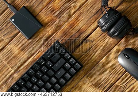 Compact Black Gaming Computer Keyboard, Headphones, External Ssd And Computer Mouse On A Table Made 
