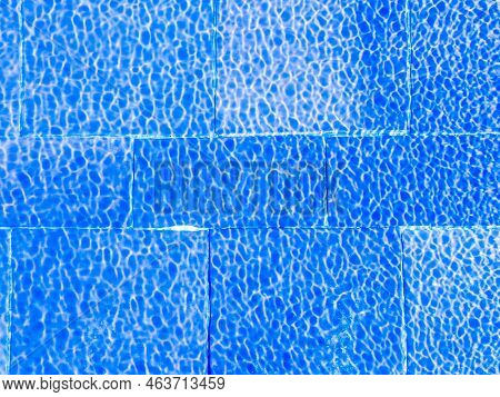 Decorative Blue Tiles Under Clear Rippeling Water At A Sunny Day