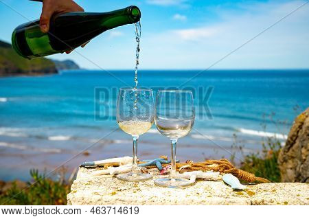 Pouring Of Txakoli Or Chacolí Slightly Sparkling Very Dry White Wine Produced In The Spanish Basque