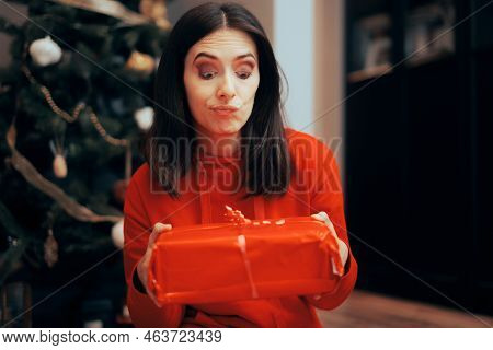 Unhappy Woman Receiving A Gift Under The Tree On Christmas