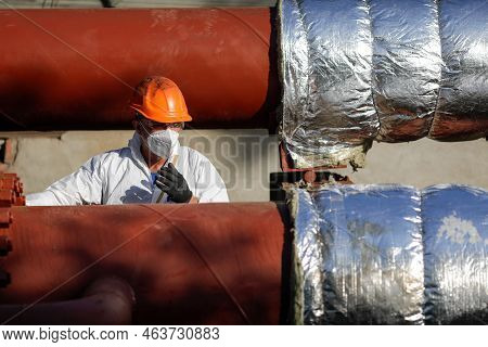 Bucharest, Romania - October 13, 2022: Worker Uses Glass Wool To Thermal Insulate A Hot Water Metall