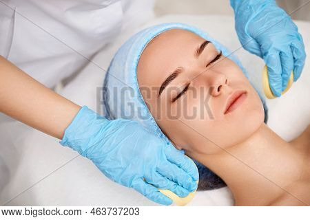 Beautician Cleanses Skin Of Beautiful Woman With A Sponge.
