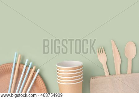 Eco - Friendly Tableware On Green Background. Top View. Plastic Free Set Of Brown Paper Utensil. Str