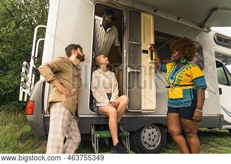 Laid-back Group Of Multi-cultural And Multi-ethnic Friends Standing In Front Of Their Camper And Loo