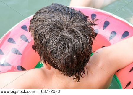 A Young Playful Happy Teenage Boy Relaxing On An Inflatable Ring , Floaty In The Sea During Summer V