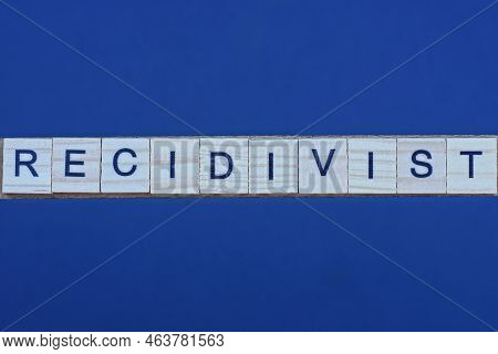 Text The Word Recidivist From Brown Wooden Small Letters On A Black Table