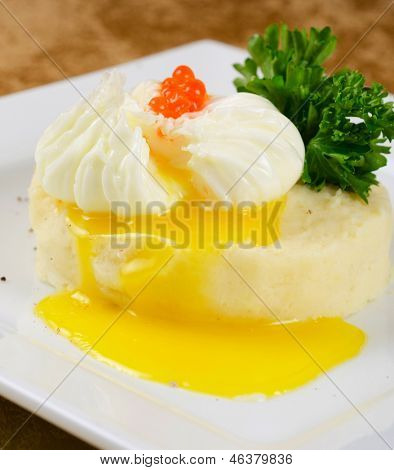 uova in camicia in un nido di purè di patate con verdure e caviale