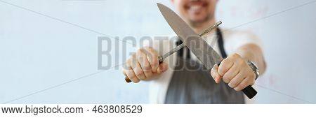 Close-up Of Standing Man Holding In Hand Sharp Kitchenware For Cooking, Knife Sharpening Process. Ch