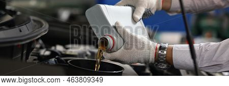 Close-up Of Man In Gloves Refueling And Pour New Fresh Oil Into Engine Motor Car. Handyman From Main