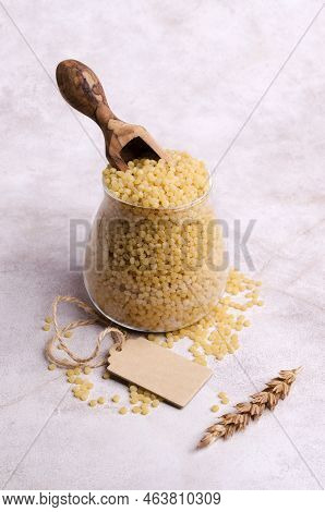 Traditional Dry Pearl Couscous In A Glass Jar On A Light Background. Selective Focus.