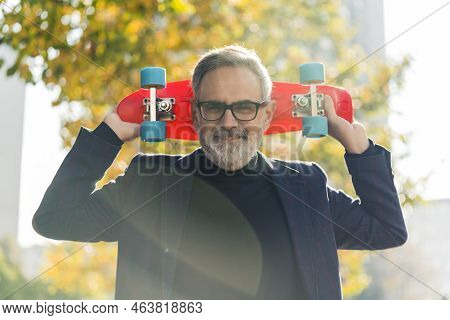 Active Autumn. Skating For Everyone. Proud Teenage-like Caucasian Grandfather With Black Glasses And