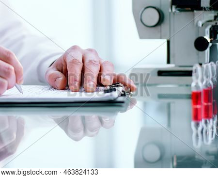 Researcher Writes Down The Results Of Research In A Laboratory Journal.