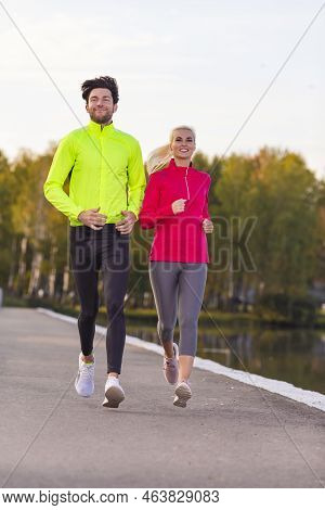 Running Couple While Training Outdoors On Road In Forest For Durable Marathon Pretty Young Female An