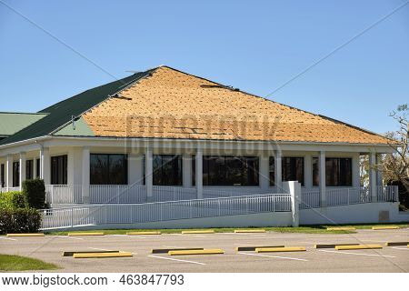 Wind Damaged House Roof With Missing Asphalt Shingles After Hurricane Ian In Florida. Repair Of Home
