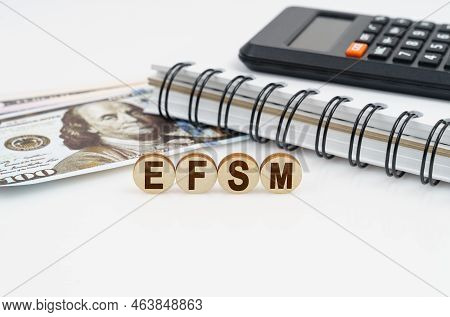 Business Concept. On A White Surface Are Dollars, A Notebook, A Calculator And Wooden Circles With T