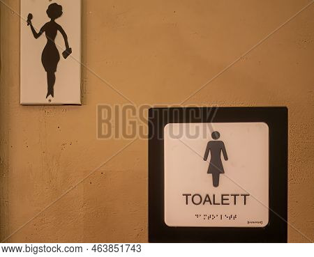 Sweden, Stockholm - July 16, 2022: Female Toilet Sign With 2 Pictograms And Text, Even In Braille