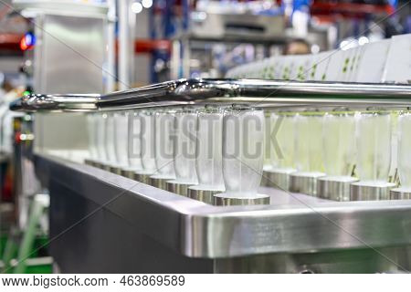 Row Glass Bottle Arrange On Automatic Bottle Washer And Sanitizing Machine In Beverage Industrial