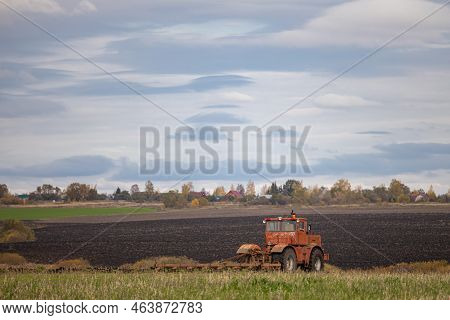 Big Old Model Tractor Plows The Ground. Farmer Plows The Land. Tractor Working In The Field. High Qu