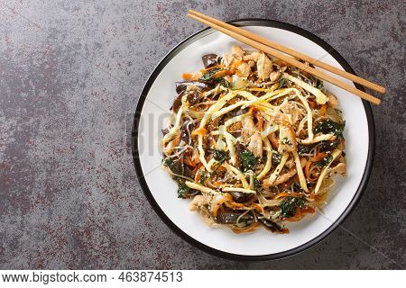 Korean Food Stir-fried With Noodles, Meat, Mushrooms And Vegetables Called Japchae Closeup On The Pl