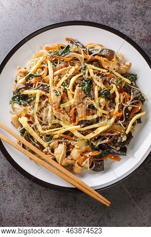Japchae Or Stir-fried Korean Vermicelli Noodles With Vegetables And Pork Topped With Sesame Closeup 