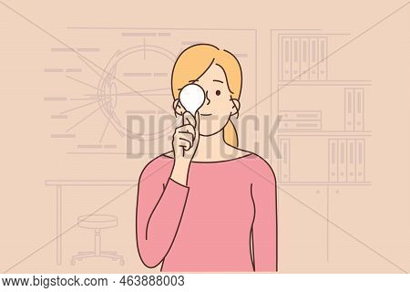 Young Woman Check Sight In Oculist Cabinet. Girl Close One Eye Examine Eyesight In Eye Doctor Clinic