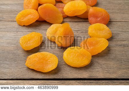 A Group Of Dried Apricots Over Wooden Table.