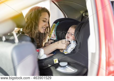 Mother Fasten Her Son In The Car Seat And Putting On His Seat Belt