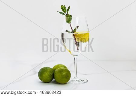 A Glass Of Water, Lemon And Mint And Lime On A White Table For Healthy Life, Energy, Thermoregulatio