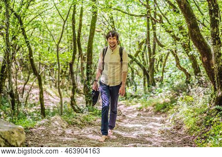 Man Tourist Climb Barefoot The Mountain To The Ostrog. It Is A Tradition To Climb Barefoot. Monaster