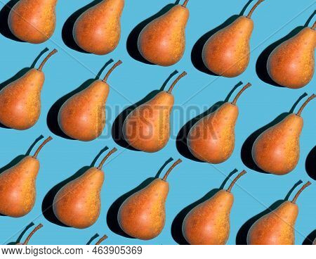 Colorful Pear Pattern. Yellow And Orange Bera Pears On A Blue Background. Ripe Juicy Fruits Top View
