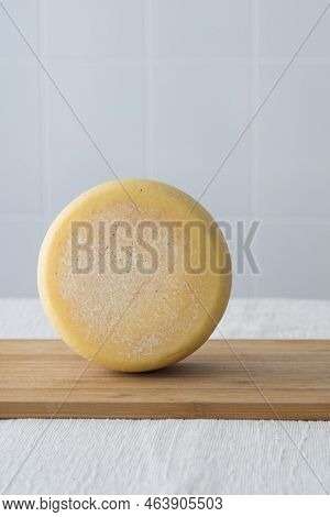 Whole Round Partmesan Or Pecorino Cheese Head On Wooden Board On Light Background. Fresh Dairy Produ