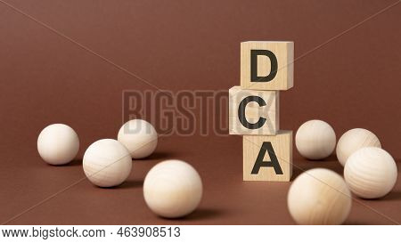 Dca - Word Is Written On Wooden Blocks On A Brown Background. Close-up Of Wooden Elements