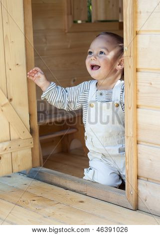 Dítě v dřevěné boudě playhouse.