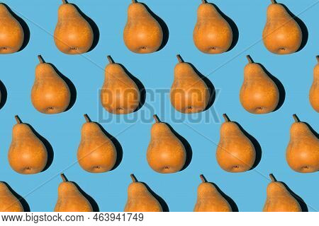 Colorful Pear Pattern. Yellow And Orange Bera Pears On A Blue Background. Ripe Juicy Fruits Top View