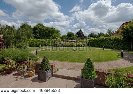 Stradishall, Suffolk, England - June 1 2017 Landscaped Garden With Patio, Circular Lawn And Shrubs