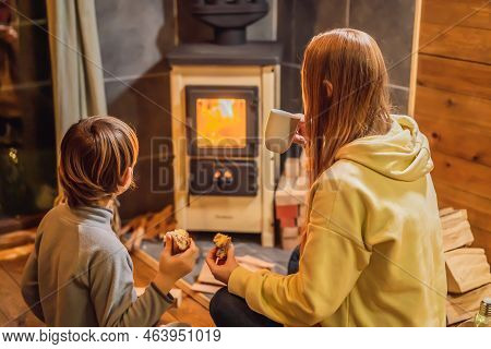 Mom And Son Spend Time By The Fireplace In Glamping. Rest In The Mountains In Glamping. Cozy Firepla